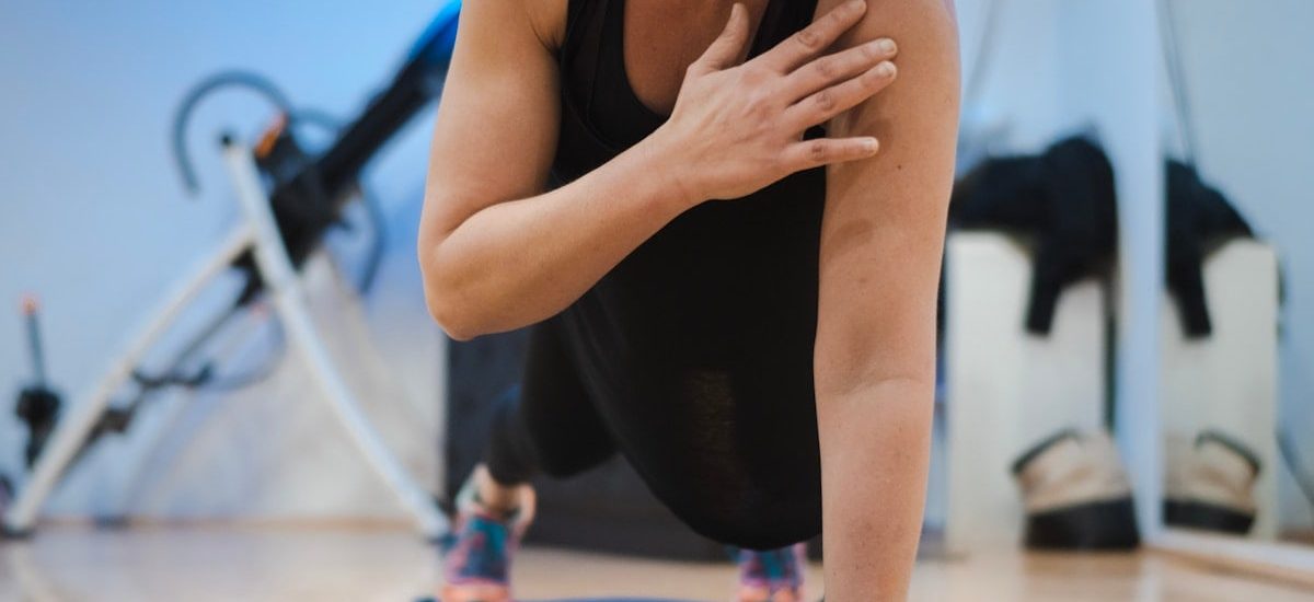 A woman in a black tank top is doing yoga