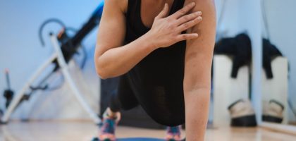 A woman in a black tank top is doing yoga